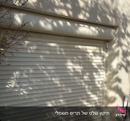 תריס גלילה חיצוני מותקן על קיר עם מצלמת אבטחה מעל